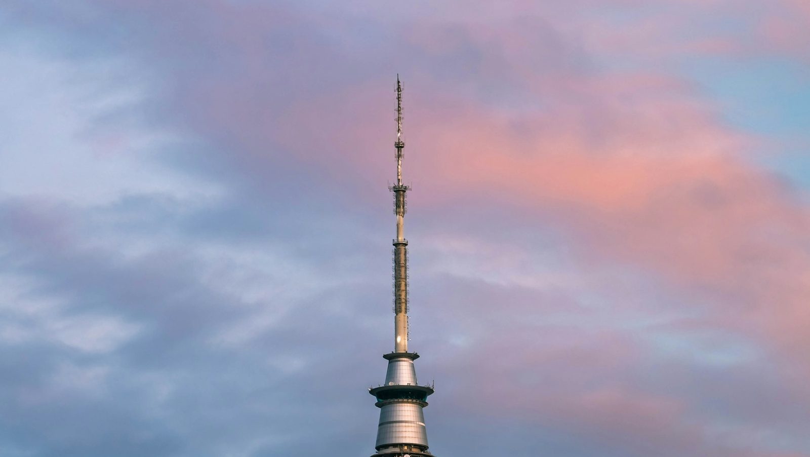 The upper part of the Sky Tower against a blue sky streaked with pink cloud