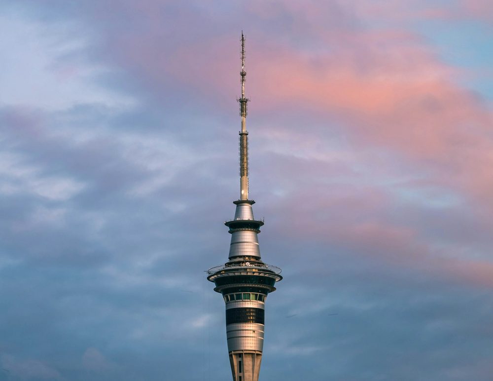 The Sky Tower under a cloudy sky with pink light